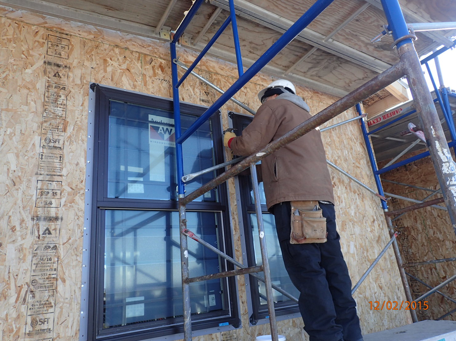Construction worker installing window at home construction site.